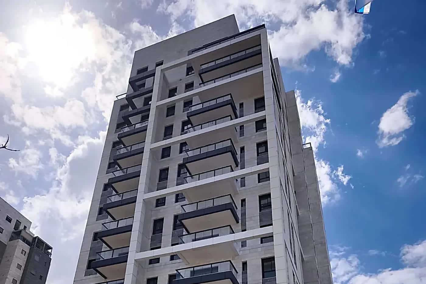 מגדל מגורים חדש ומודרני בישראל על רקע שמיים כחולים - בדק בית לדירה חדשה ובדיקת איכות בנייה לפני מסירה מהקבלן