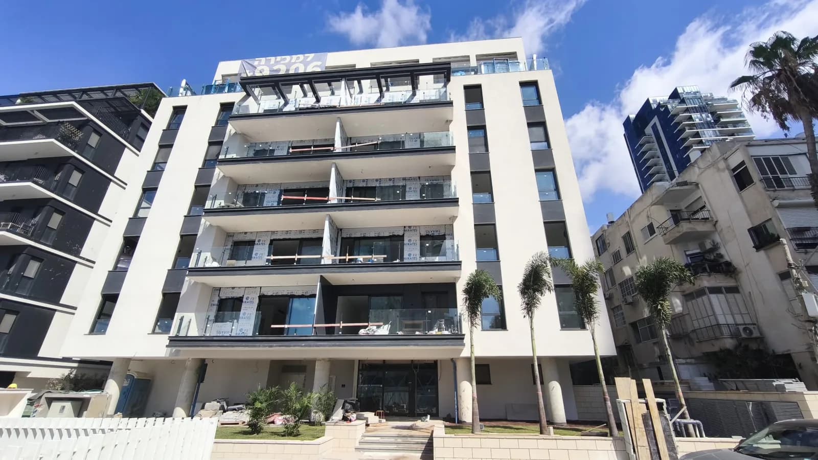 בניין מגורים בוטיק חדש בתל אביב לקראת מסירה בניין מגורים בוטיק חדש בתל אביב בשלבי סיום - מרפסות עם מעקה זכוכית וחלונות עטופים לפני מסירת הדירות מהקבלן