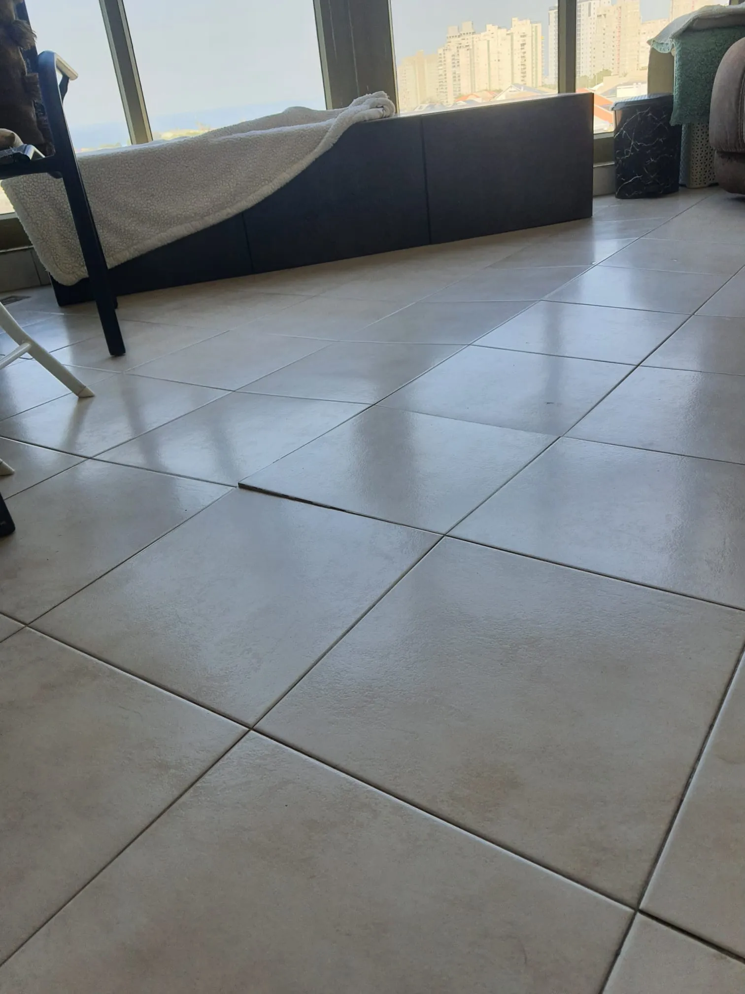 התרוממות ריצוף עקב מישקים צפופים אריח ריצוף שהתרומם והתנתק מהרצפה עקב מישקים צפופים מדי ללא מרווח להתפשטות - ליקוי ריצוף שאותר בבדק בית