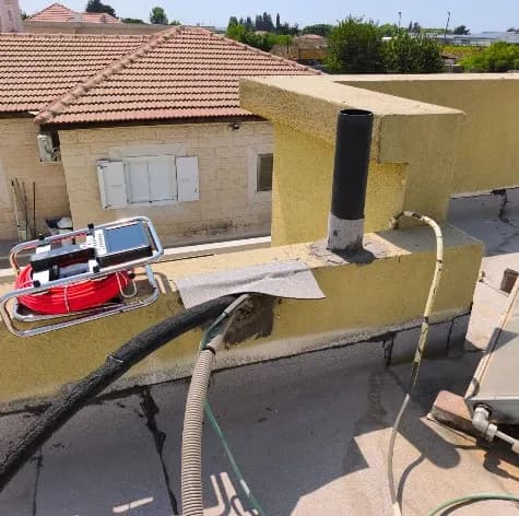 צינור פתוח בגג ללא מקל סבא וללא מכסה גשם צינור אנכי פתוח בראש קיר מעקה בגג, ללא כיפוף מקל סבא וללא מכסה מגן מפני גשם, לצד סדק פתוח בקיר המעקה - ליקוי שמכניס מי גשם ישירות לצנרת ולמבנה