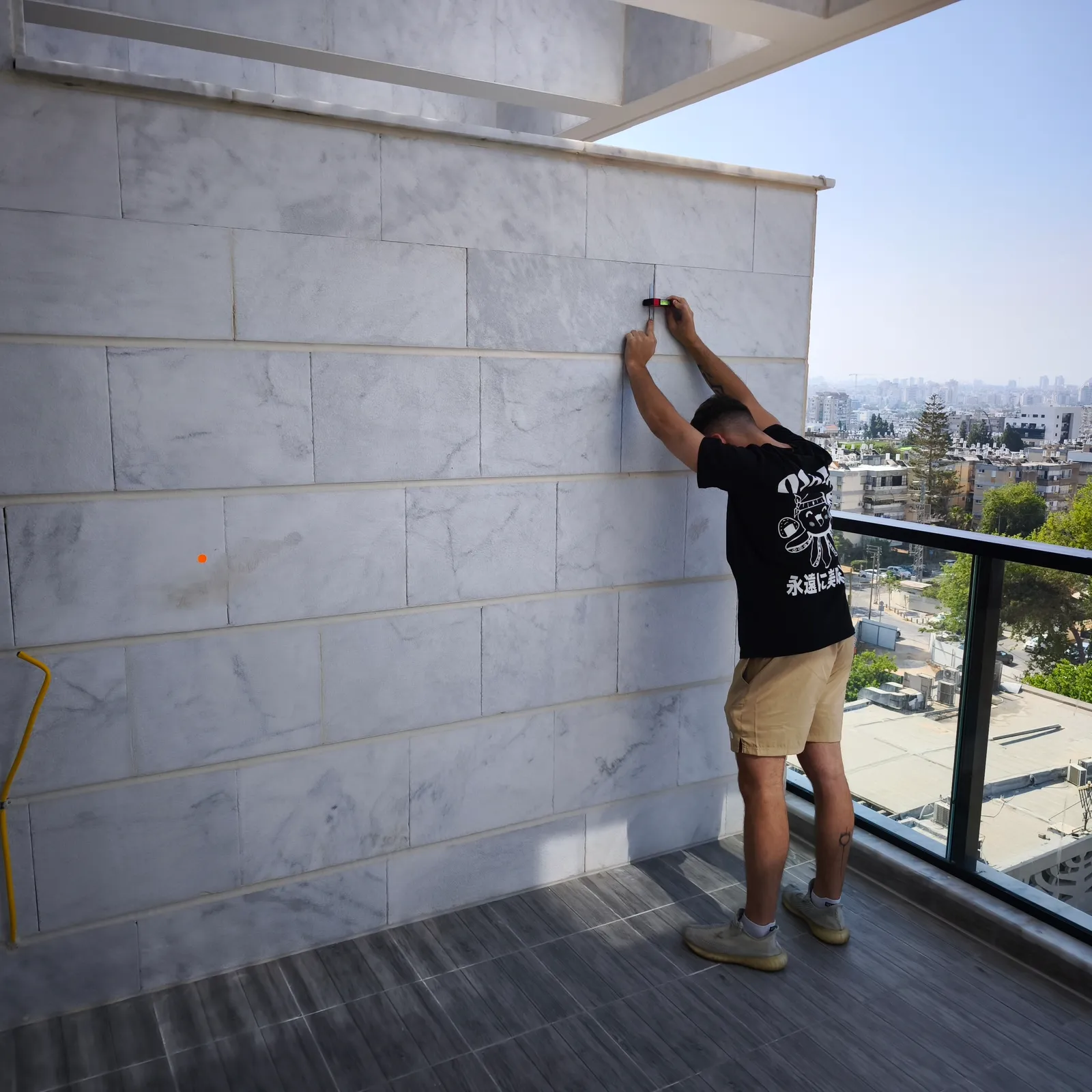 בדיקת חיפוי אבן וקיר מרפסת בעזרת מכשיר מדידה - איתור ליקויי חיפוי, מישוריות ורטיבות בבדק בית